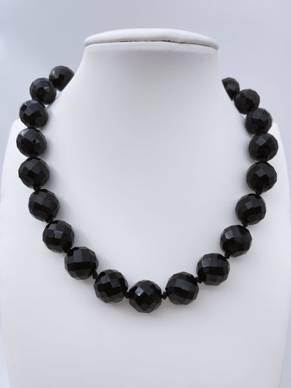 Fasetinių juodo stiklo karoliukų vėrinys